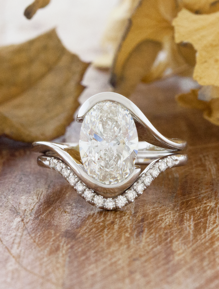 caption:Paired with custom curved Catherine wedding band with 2ct oval diamond in platinum 